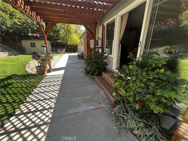 view of patio with an outdoor structure, fence, and a pergola