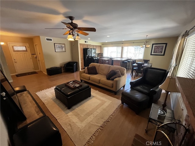 living room featuring visible vents, recessed lighting, ceiling fan with notable chandelier, and wood finished floors