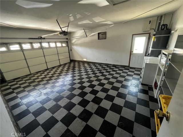 garage featuring baseboards, a garage door opener, and independent washer and dryer