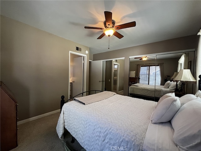 carpeted bedroom with two closets, a ceiling fan, baseboards, and visible vents