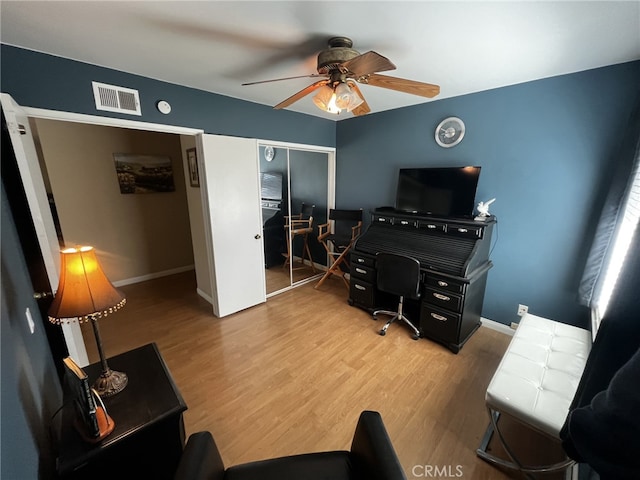 home office featuring baseboards, ceiling fan, light wood-type flooring, and visible vents