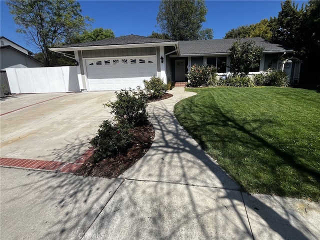 ranch-style home featuring fence, a front yard, stucco siding, concrete driveway, and an attached garage