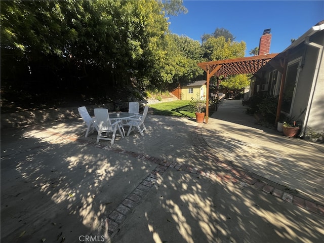 view of patio / terrace with a storage unit, an outdoor structure, outdoor dining area, and a pergola