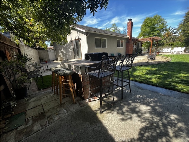 view of patio / terrace featuring fence, a pergola, and outdoor dry bar