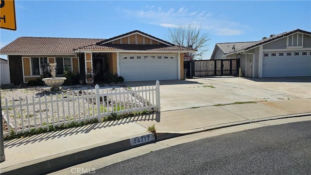 ranch-style home with fence, a tiled roof, a garage, and concrete driveway