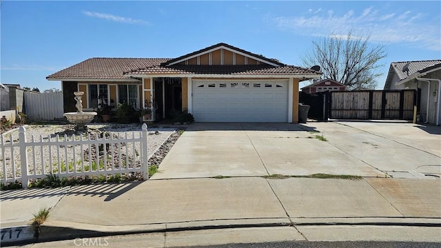 ranch-style house featuring driveway, a gate, fence, an attached garage, and a tiled roof