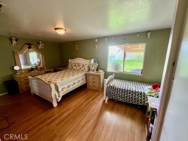 bedroom featuring visible vents, wood finished floors, and a textured ceiling