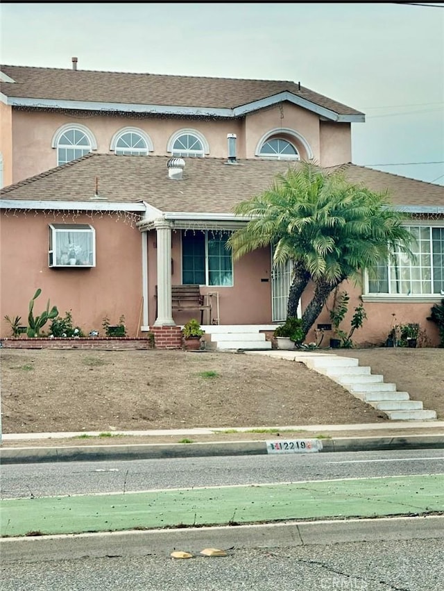 view of front of home featuring stucco siding and a shingled roof