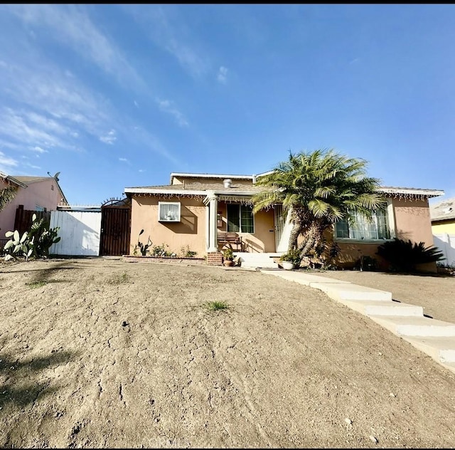 view of front of property featuring a gate and stucco siding
