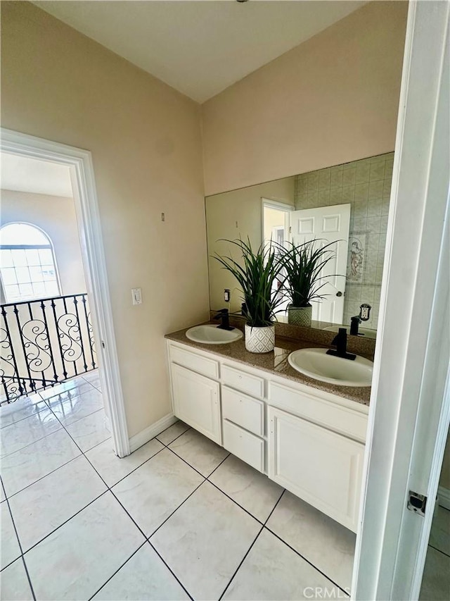 full bath featuring double vanity, tile patterned floors, and a sink
