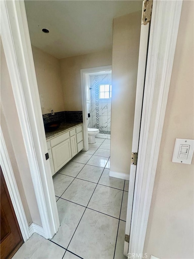 bathroom with toilet, tile patterned flooring, and vanity