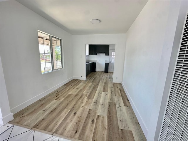 12219 S Main St, Los Angeles, CA 90061 - unfurnished living room featuring a heating unit and light wood finished floors