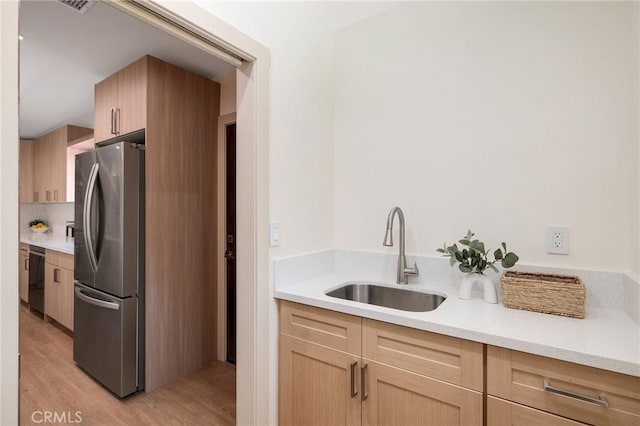 5306 Maricopa St, Torrance, CA 90503 - kitchen with freestanding refrigerator, light wood finished floors, black dishwasher, light brown cabinetry, and light countertops