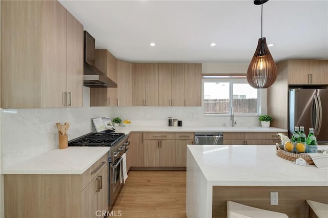5306 Maricopa St, Torrance, CA 90503 - kitchen featuring appliances with stainless steel finishes, light brown cabinetry, wall chimney exhaust hood, backsplash, and pendant lighting