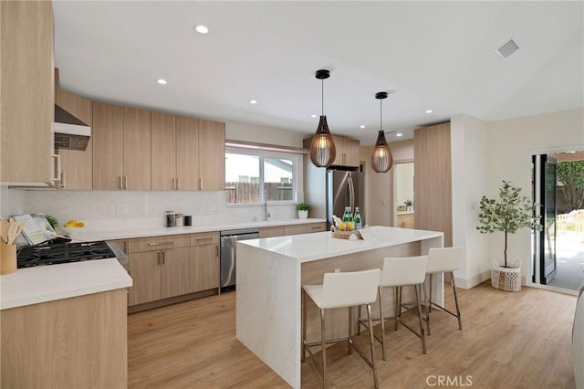 5306 Maricopa St, Torrance, CA 90503 - kitchen with stainless steel appliances, light brown cabinetry, a breakfast bar, healthy amount of natural light, and recessed lighting
