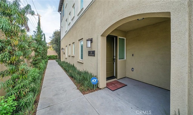 doorway to property with stucco siding and a patio