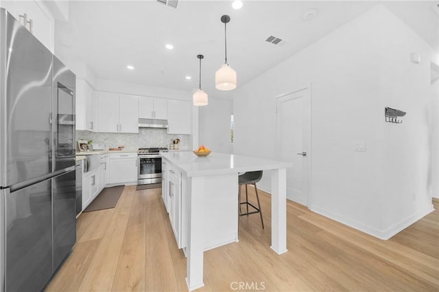 kitchen with light wood-style floors, visible vents, appliances with stainless steel finishes, and under cabinet range hood