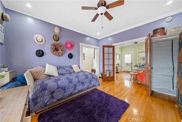 bedroom with a ceiling fan, crown molding, french doors, and hardwood / wood-style floors
