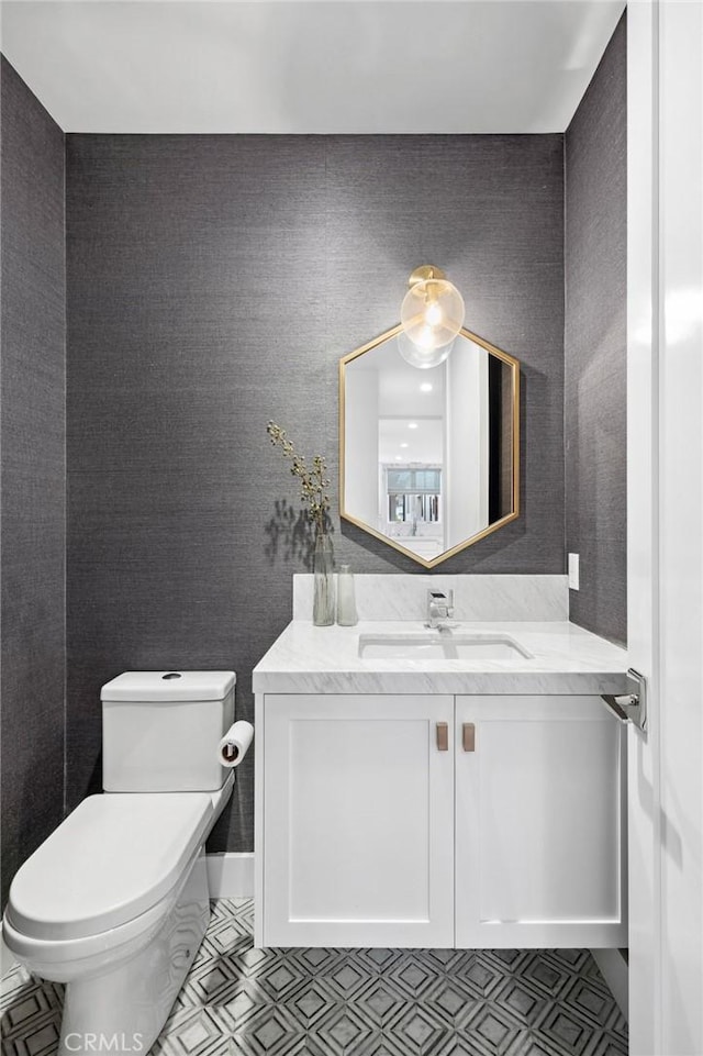 half bath featuring vanity and toilet
