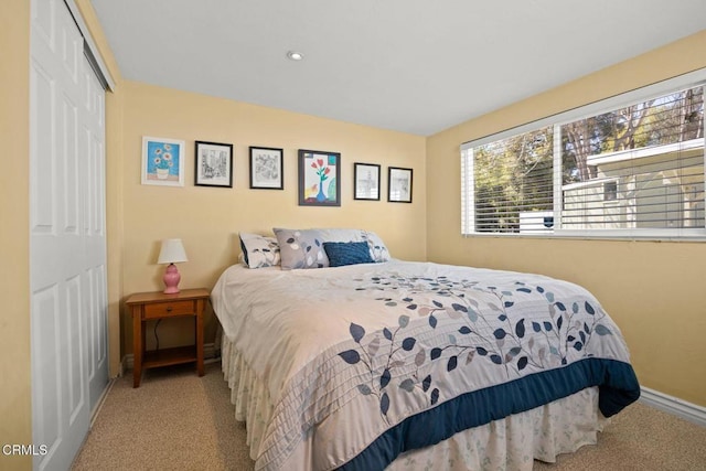 carpeted bedroom with baseboards and a closet