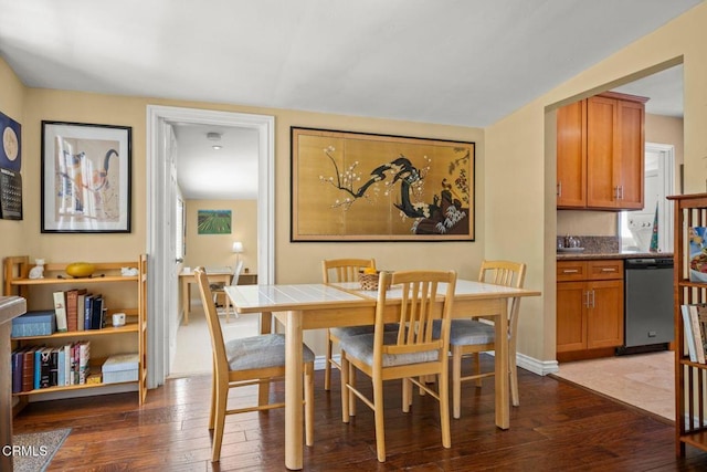 dining space featuring dark wood-style floors and baseboards