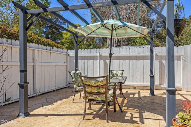 view of patio with a fenced backyard, outdoor dining space, and a pergola
