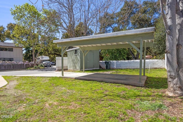 view of yard with an outdoor structure, a shed, and fence