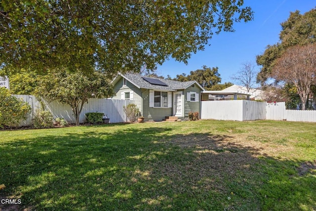 exterior space with a fenced backyard, a front yard, solar panels, and entry steps