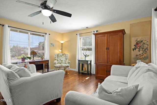 living area featuring dark wood-type flooring, a wealth of natural light, baseboards, and ceiling fan