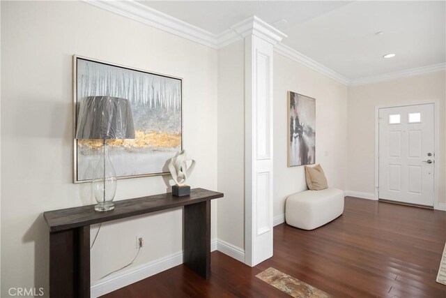 foyer entrance with crown molding, baseboards, and wood finished floors