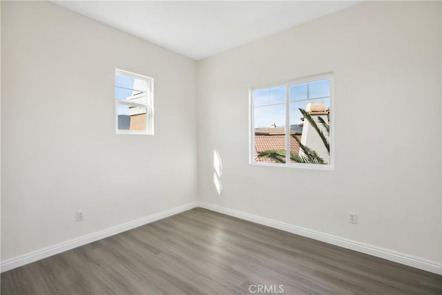 unfurnished room featuring baseboards and wood finished floors