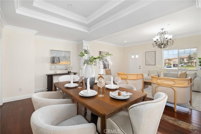 dining area featuring a notable chandelier, crown molding, a raised ceiling, wood-type flooring, and baseboards