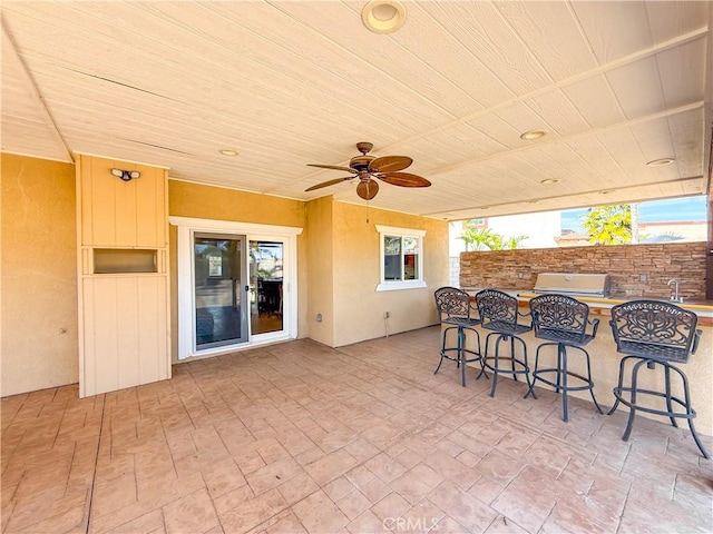 view of patio / terrace with grilling area, exterior kitchen, ceiling fan, and outdoor wet bar