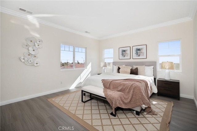 bedroom with baseboards, visible vents, wood finished floors, and ornamental molding