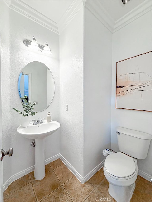 bathroom with toilet, tile patterned flooring, baseboards, visible vents, and ornamental molding