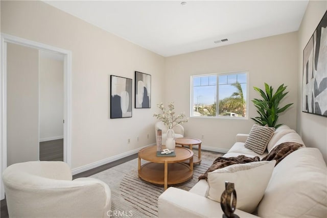 living room with visible vents, baseboards, and wood finished floors