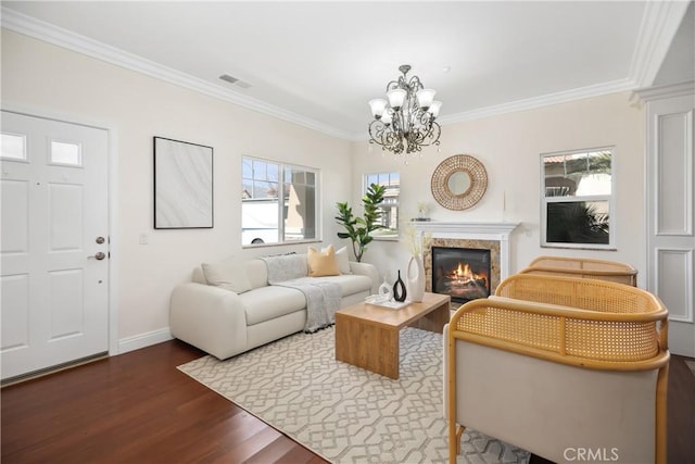 living room with visible vents, ornamental molding, wood finished floors, and an inviting chandelier