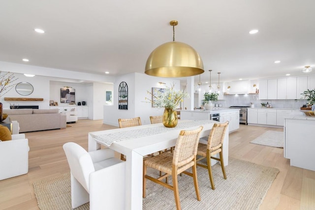 dining space with recessed lighting and light wood-style flooring