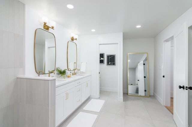 bathroom featuring double vanity, a sink, tile patterned floors, and recessed lighting