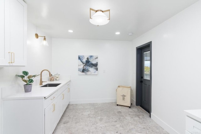 bar featuring baseboards, a sink, and recessed lighting