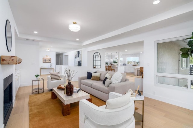living room with recessed lighting, baseboards, light wood finished floors, and a fireplace