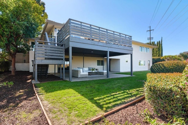 rear view of house featuring a lawn, a wooden deck, a patio area, an outdoor hangout area, and stucco siding