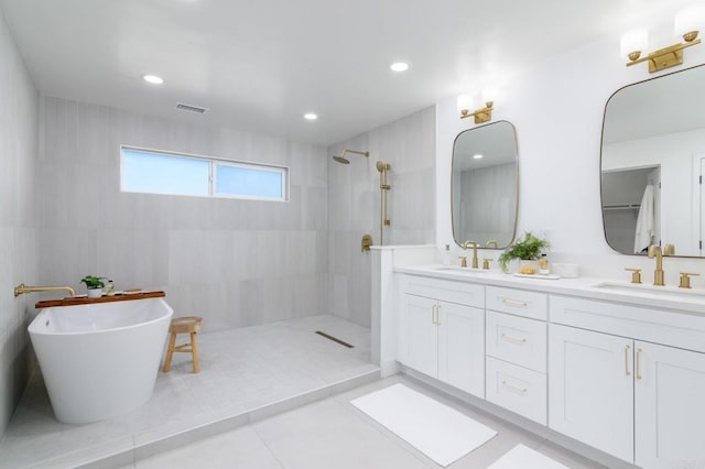 bathroom featuring visible vents, a sink, walk in shower, and double vanity