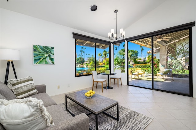living room featuring lofted ceiling, baseboards, an inviting chandelier, and light tile patterned flooring