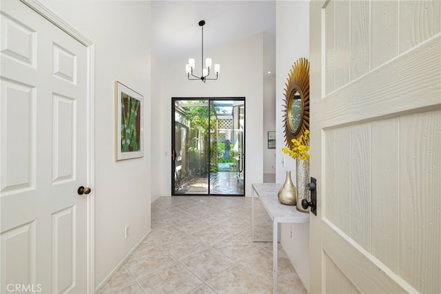 interior space with light tile patterned flooring, a high ceiling, baseboards, and an inviting chandelier