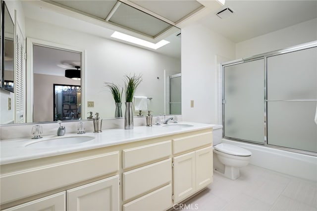full bath featuring a sink, double vanity, toilet, visible vents, and enclosed tub / shower combo