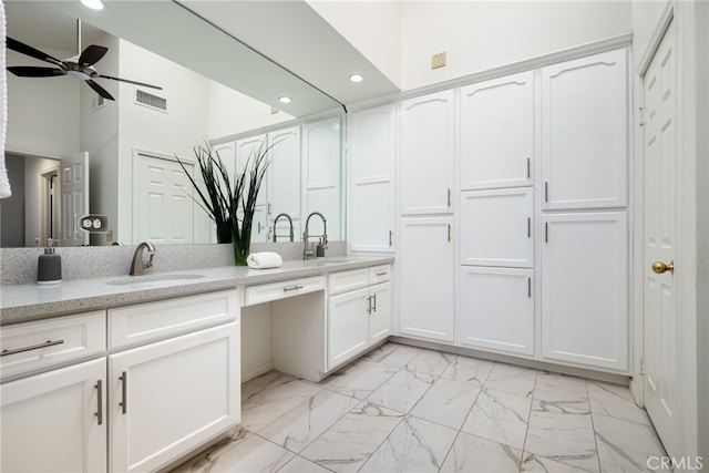 full bath with marble finish floor, double vanity, a ceiling fan, and a sink