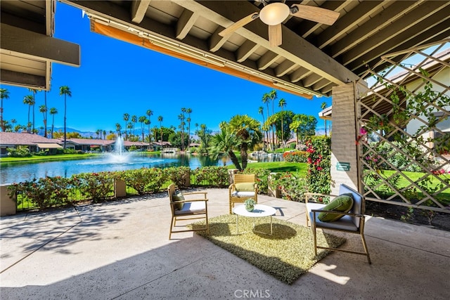 view of patio featuring a water view and a ceiling fan