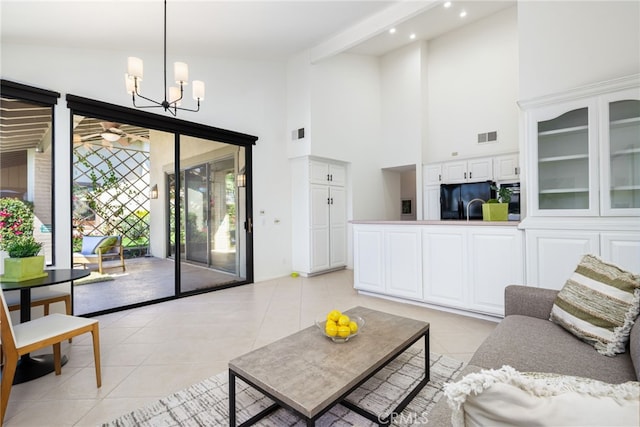 living area with light tile patterned flooring, visible vents, and high vaulted ceiling