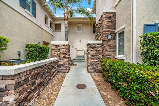 view of exterior entry with stone siding and stucco siding